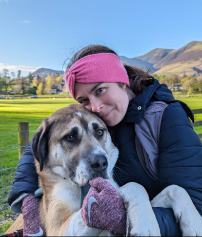 Sara Alexander smiling next to a dog.